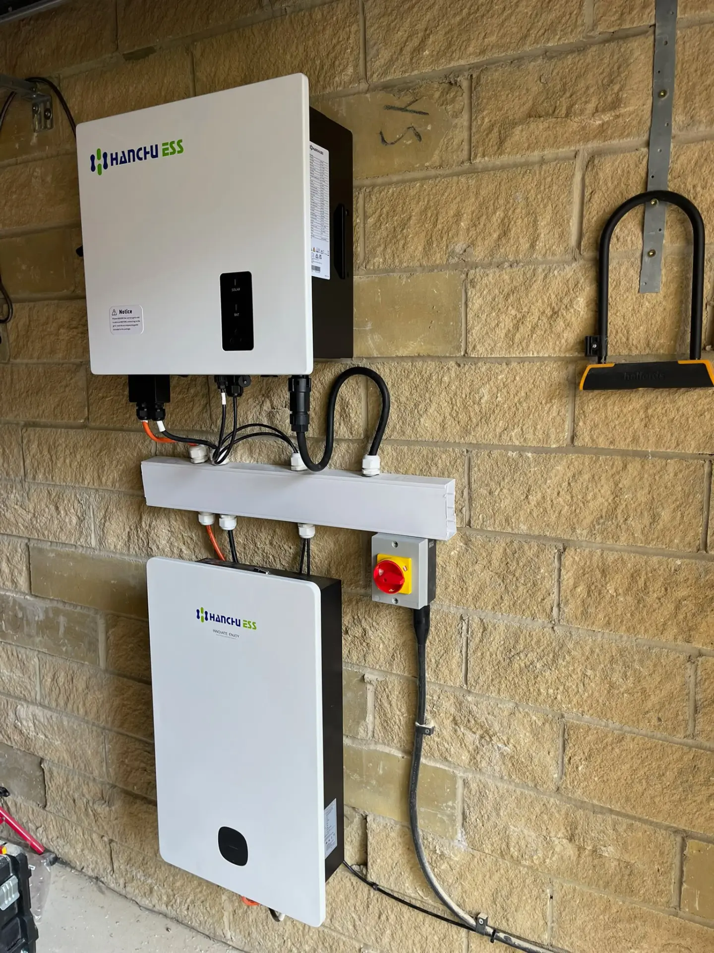 Hanchu hybrid inverter and battery storage unit installed on a garage wall